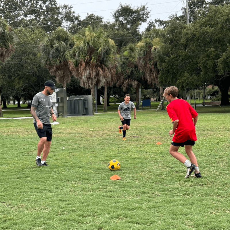 Boys at overnight sports camp practicing short pass circuits with professional soccer player Nicky Law