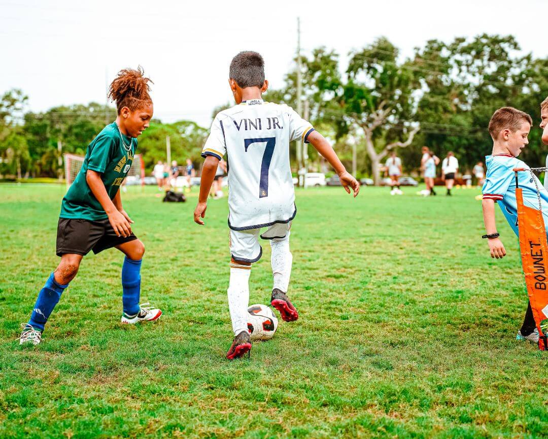 Two boys facing off during a soccer scrimmage at signature sports camp
