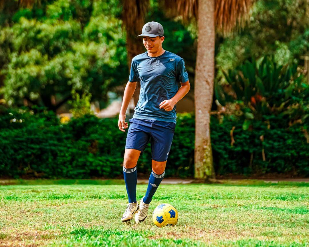 Soccer coach demonstrating ball dribbling at signature sports camp
