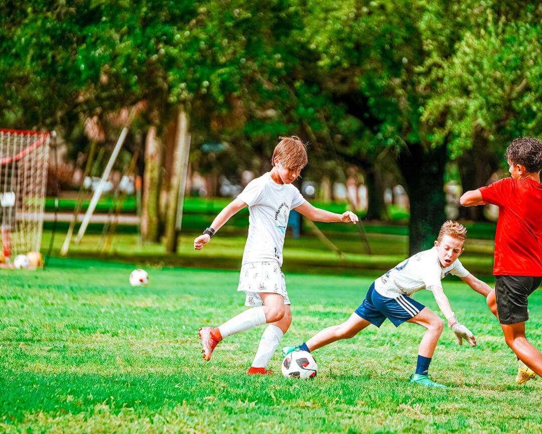 Boys playing a 3 on 3 soccer tournament at sports camp