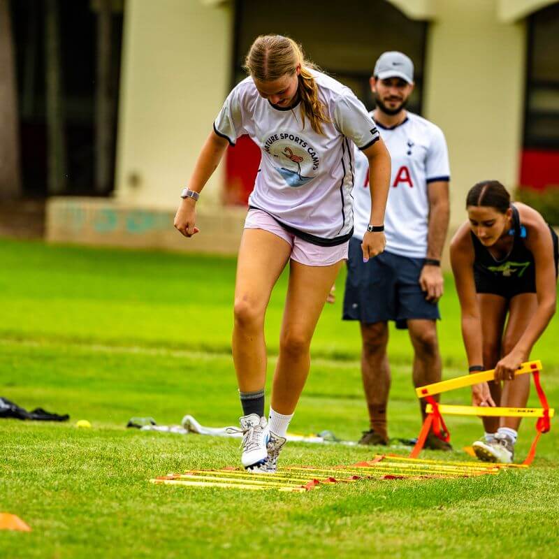 Girl wearing signature sports camp jersey practicing speed and agility drills during soccer camp