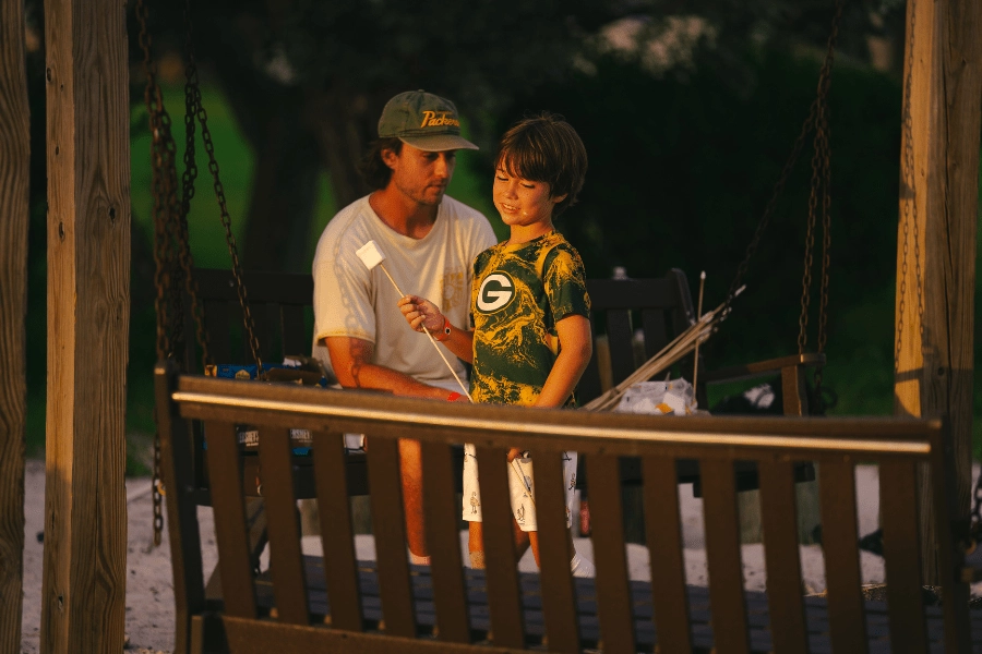 camper at overnight sports camp holding a marshmallow ready to roast