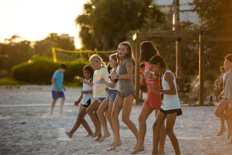 Young girls dancing on the beach at Lacrosse summer camp