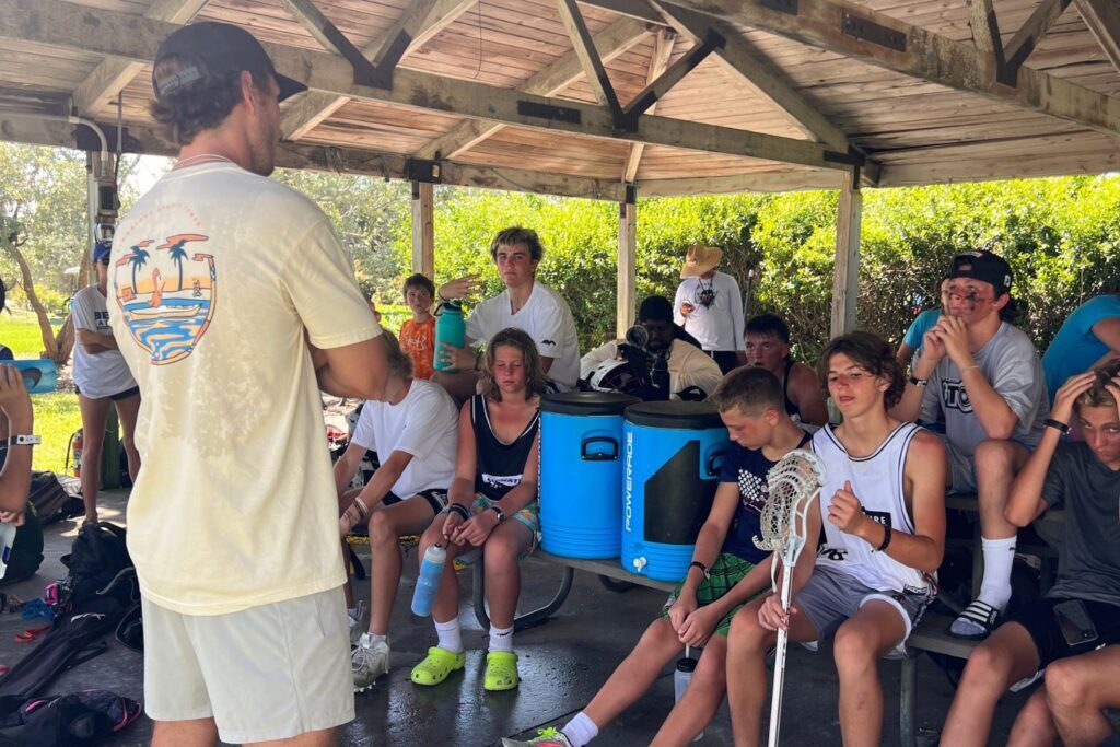 Professional lacrosse player addressing a crowd of young lacrosse players at overnight sports camp