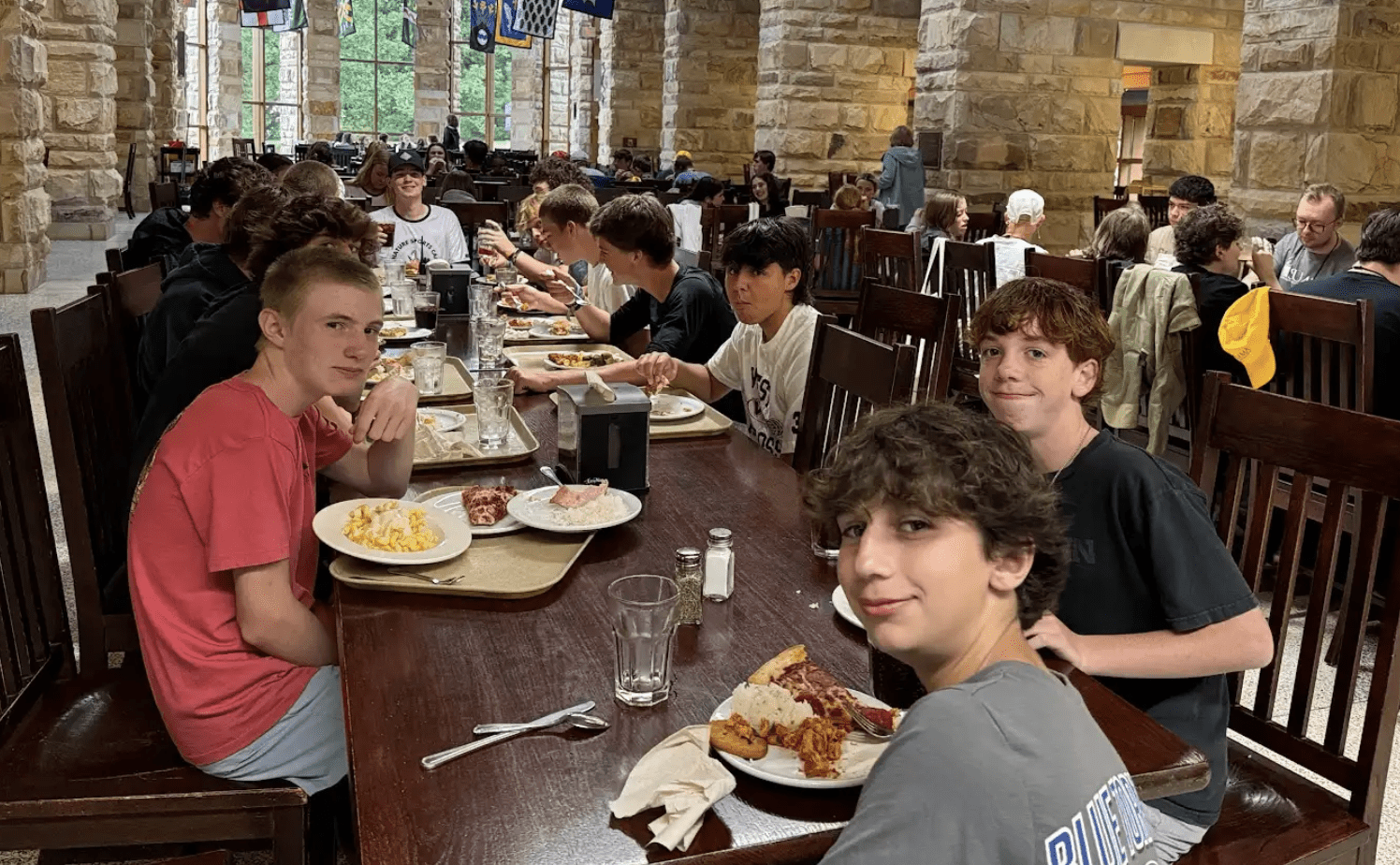 A group of boys enjoying dinner together at Signature Sports Camps, demonstrating the importance of balanced meals and healthy eating habits that support young athletes during their post-holiday nutrition reset.