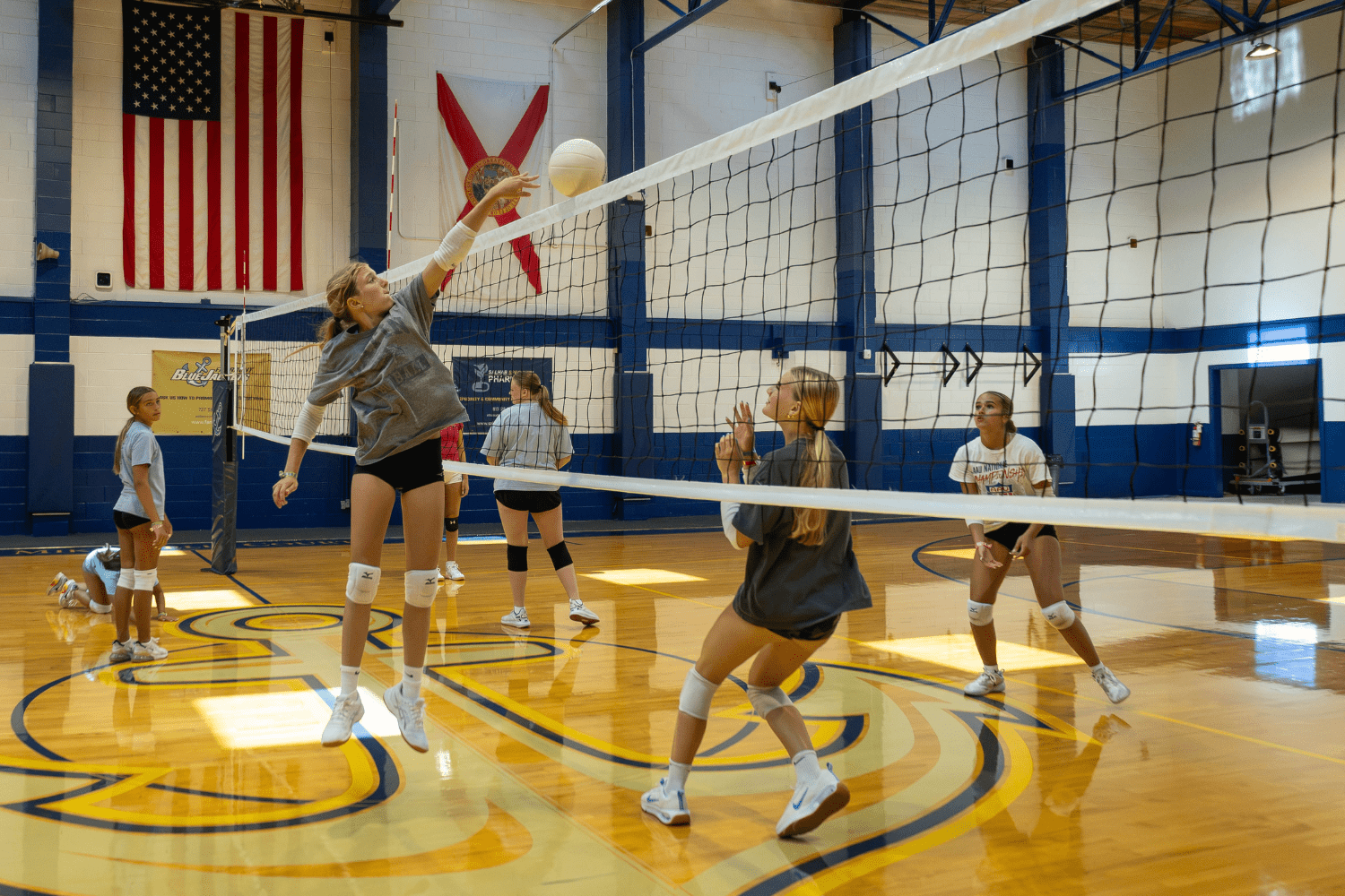 Girls practicing volleyball on an indoor court at Signature Sports Camps