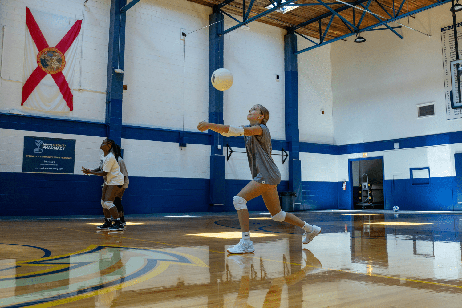 Girl practicing volleyball indoors at Signature Sports Camps