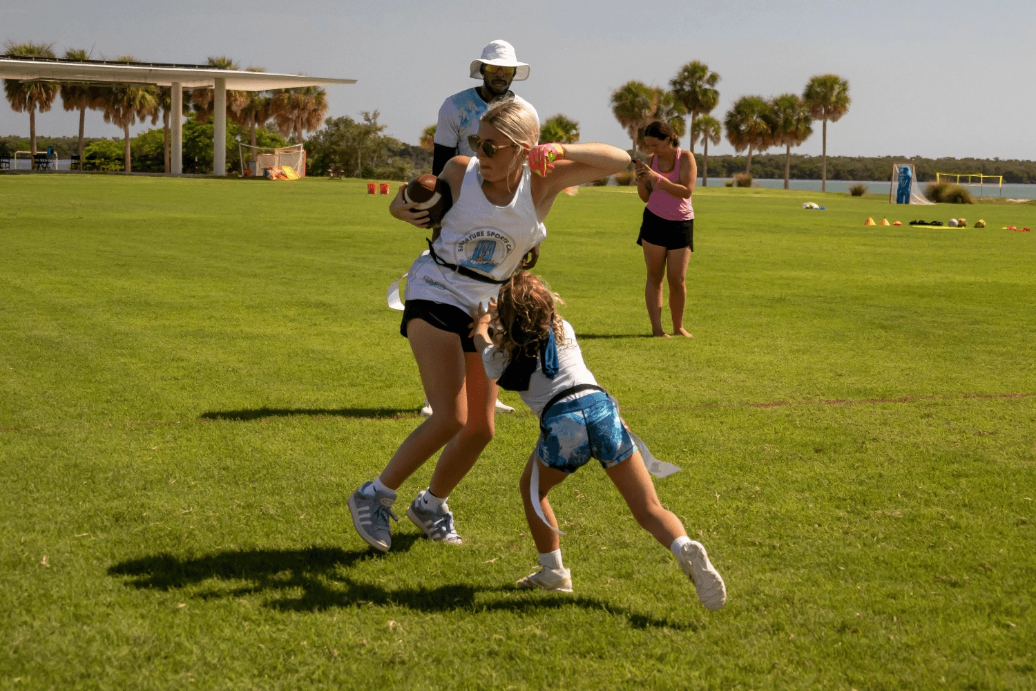 Girls at Signature Sports Camps during flag football practice outdoors