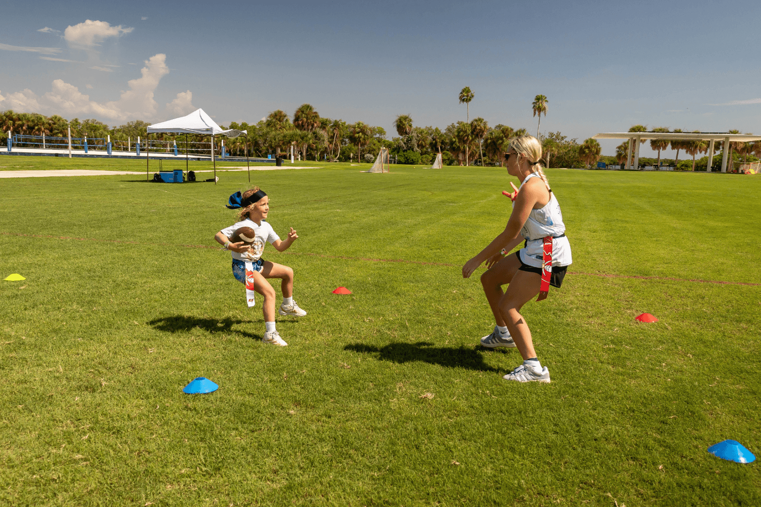 Girls at Signature Sports Camps during flag football practice outdoors