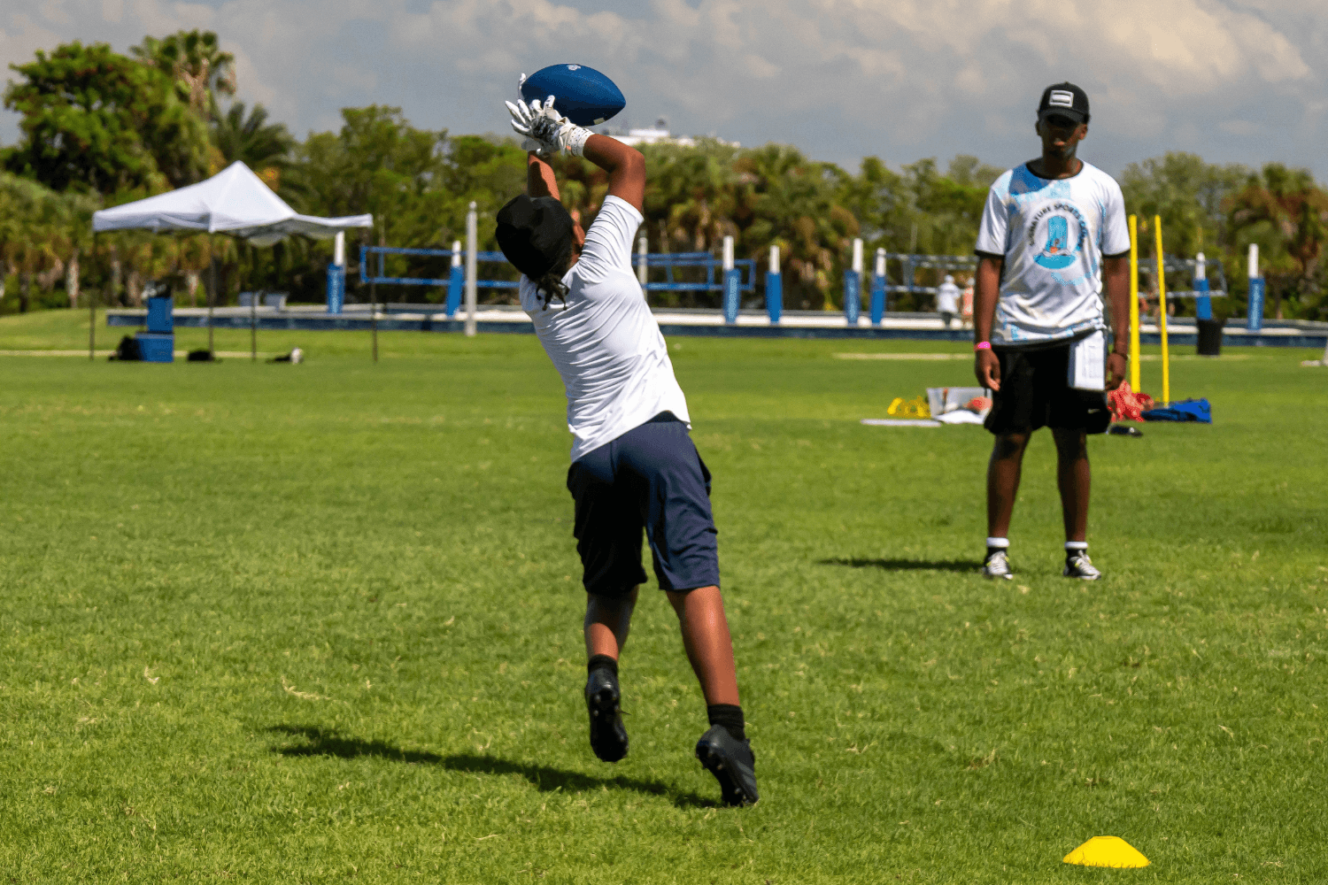 Boy catching a football during flag football practice at Signature Sports Camps