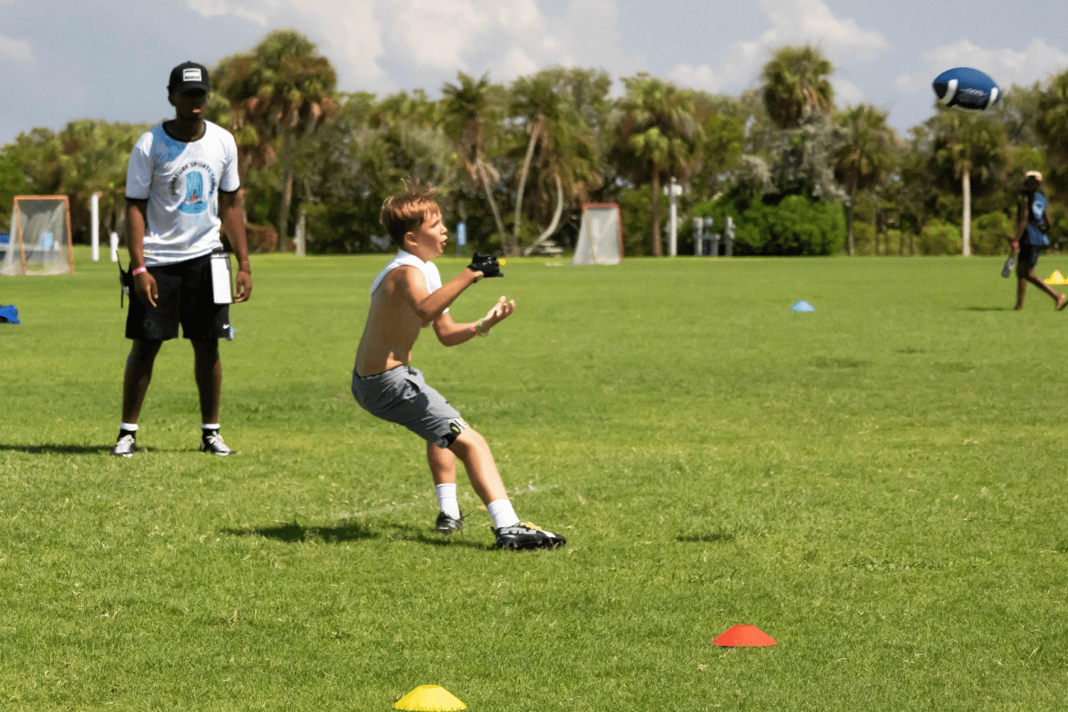 Boy catching a football during flag football practice at Signature Sports Camps