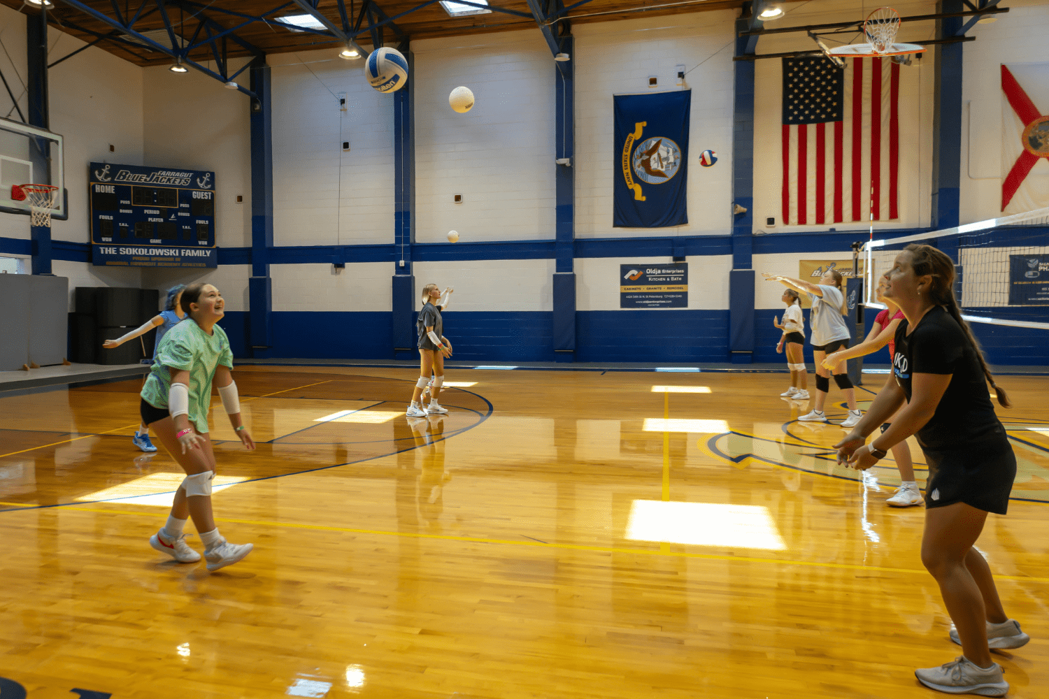 Group of girls practicing volleyball indoors at Signature Sports Camps