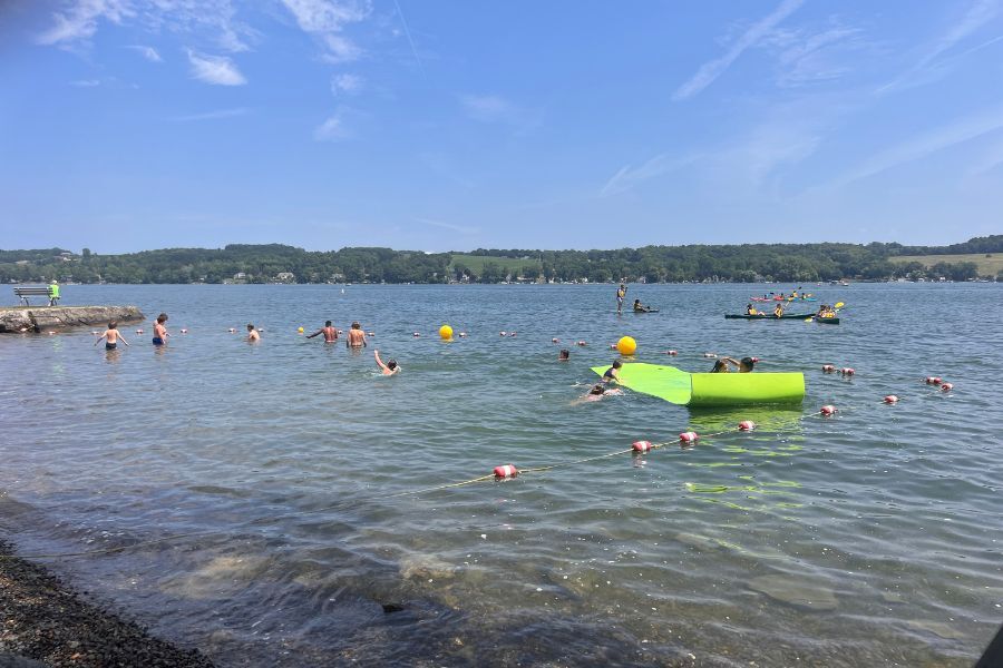 Signature Summer Campers on Lake Keuka kayaking and splashing on the lily pad