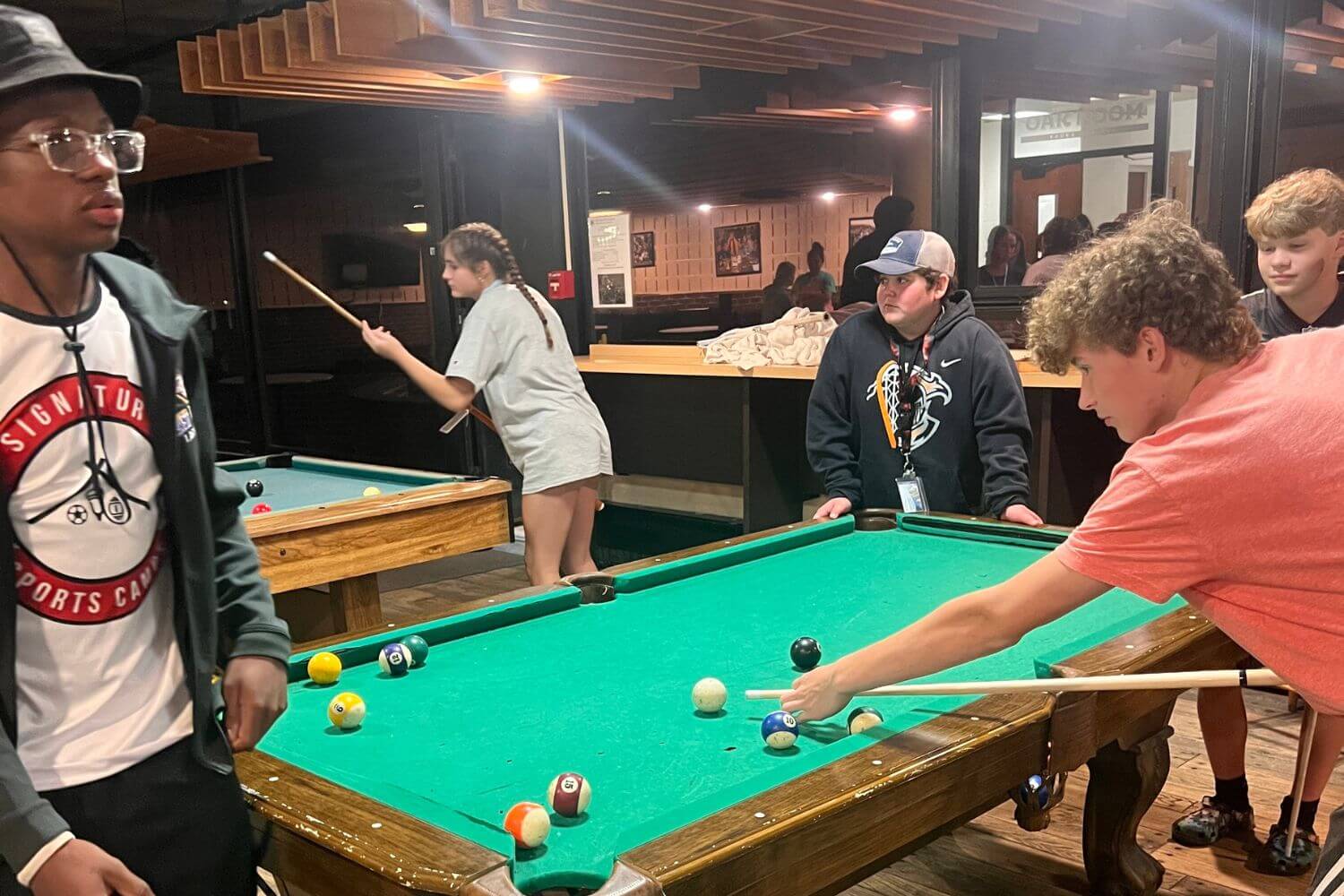 Boys playing a game of pool during canteen time at summer camp