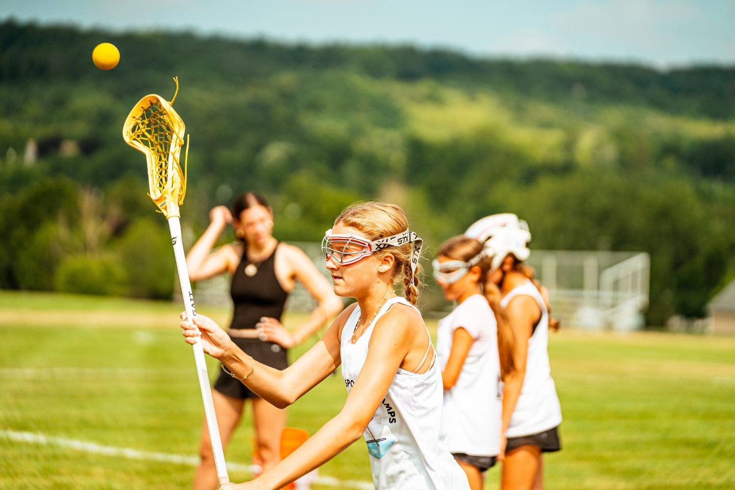 Girl with lacrosse stick during practice at sports camp