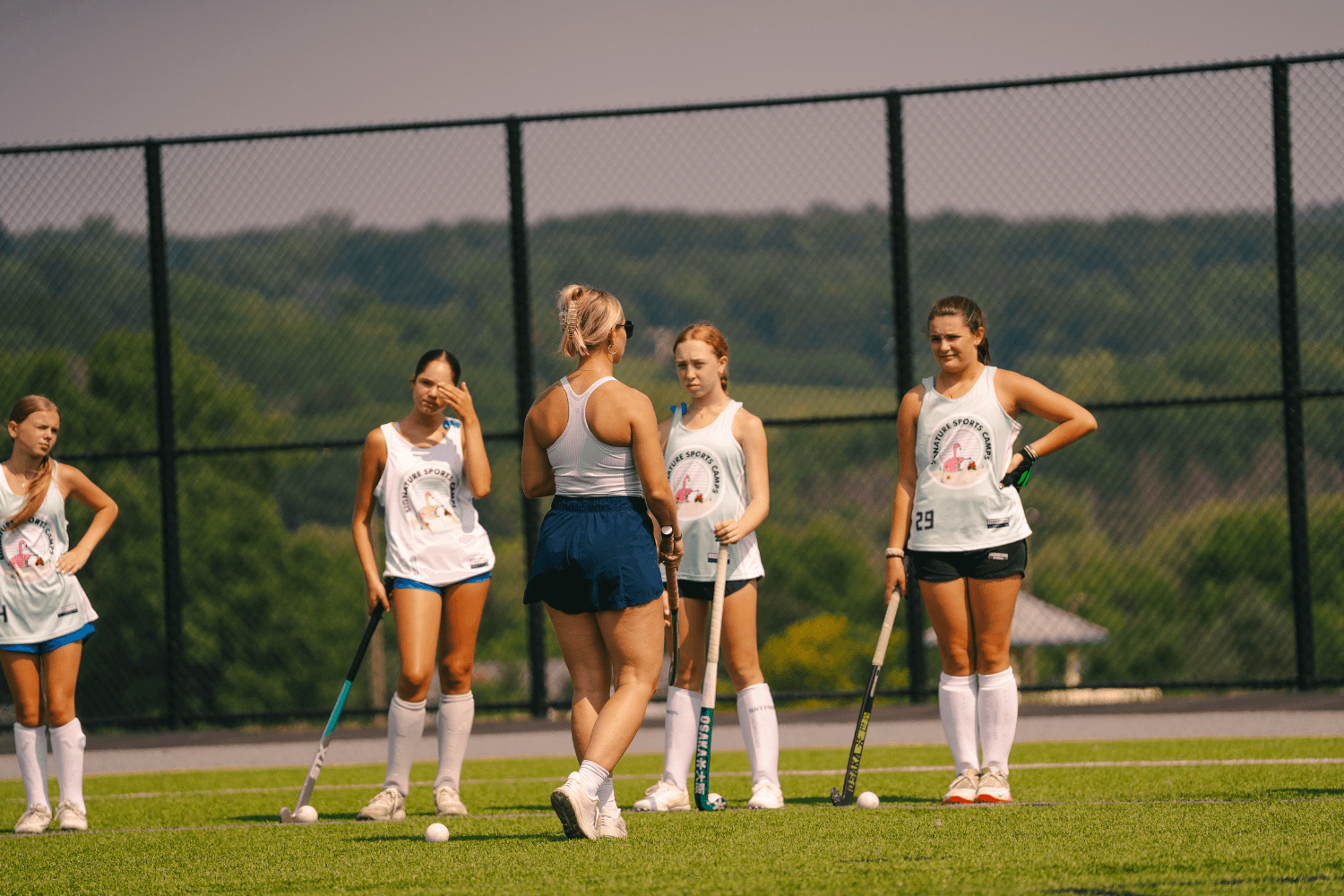 Girls learning from field hockey pro at overnight sports camp