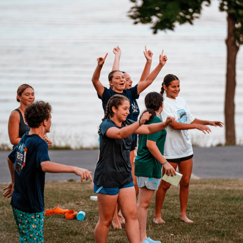 Group of kids cheering during a game at sports camp