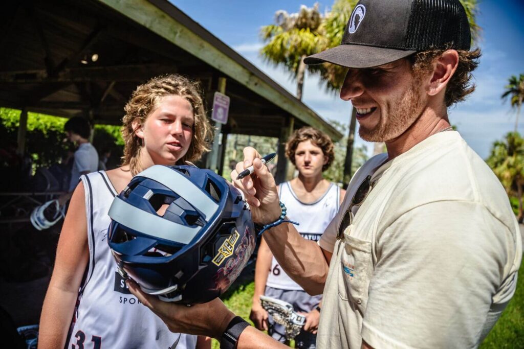 Professional Lacrosse player Andrew Kew signing autographs after a practice session at Signature's overnight sports camp