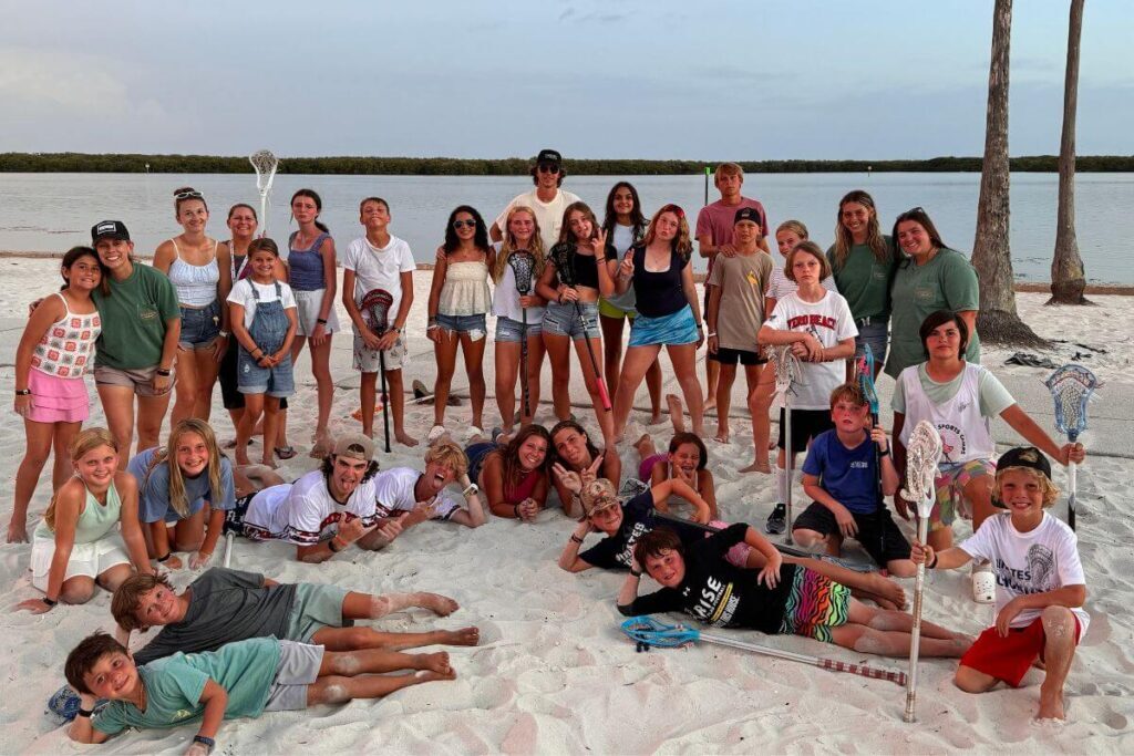 Group of young campers at Signature Sports Camp pose for a photo on the beach