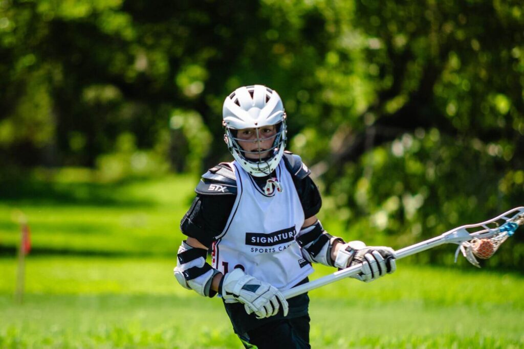 A lacrosse player practicing cradling, a lacrosse drill for beginners