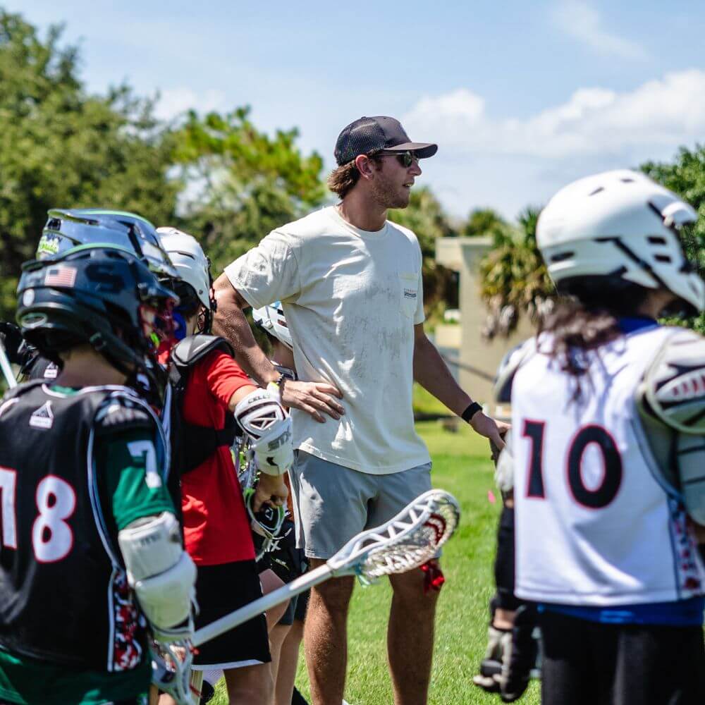 A professional Lacrosse player is coaching a team of lacrosse campers