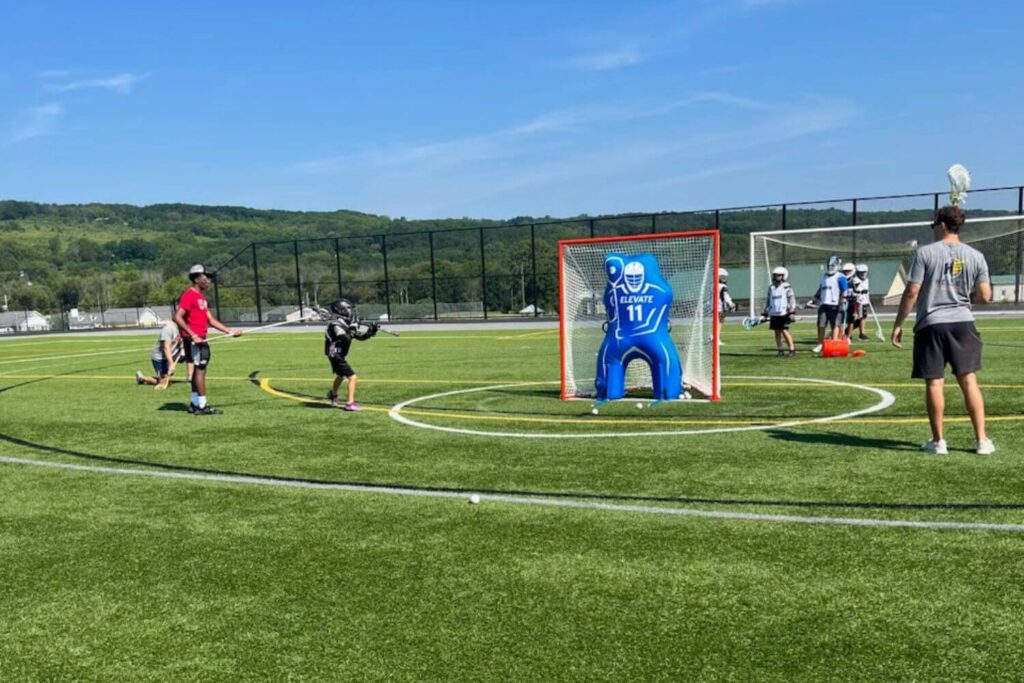 Professional lacrosse players hosting a practice session with lacrosse campers in NY