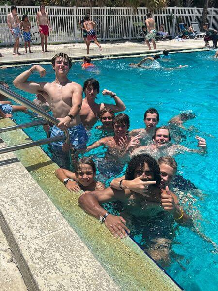 A group of boys at lacrosse camp enjoying swimming pool time during a break