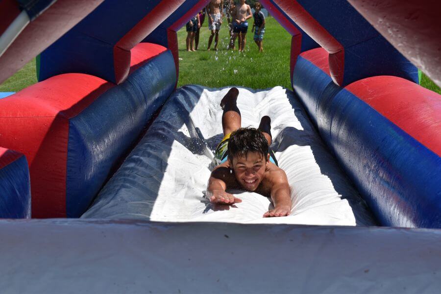 A young boy is coming head first down a waterslide