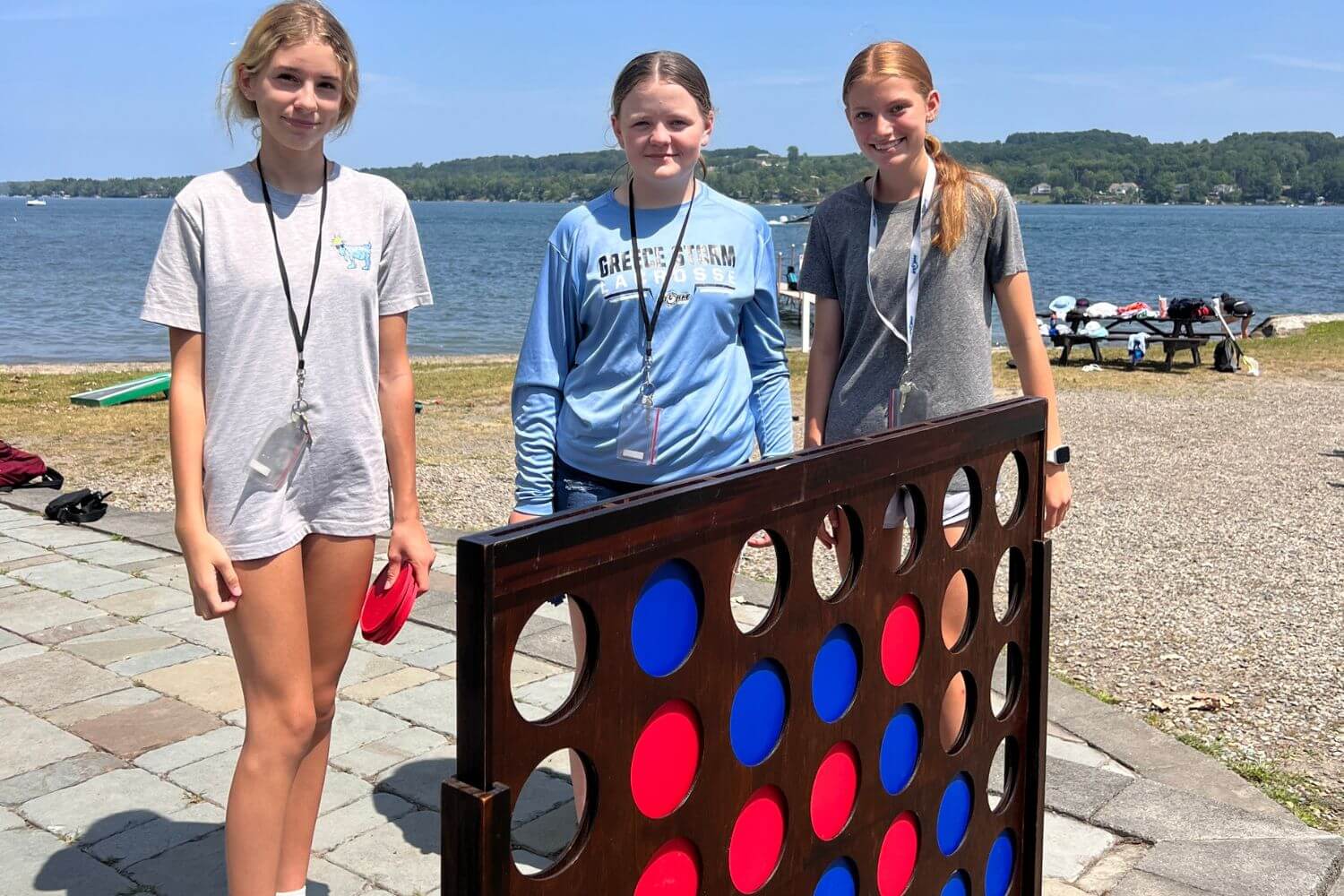 Three girls playing jumbo connect four at summer camp