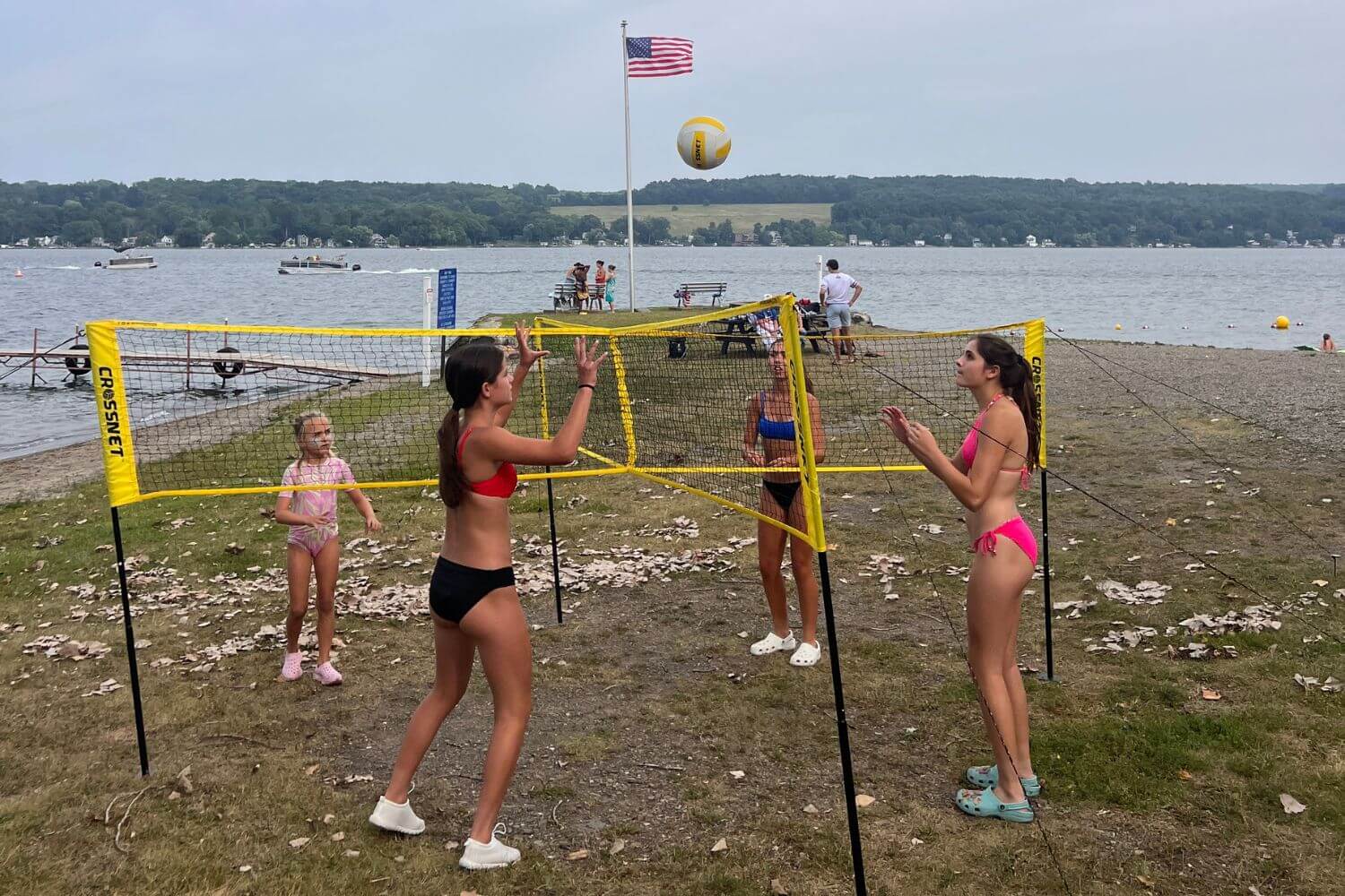 Girls playing a game of crossnet by the water at summer camp