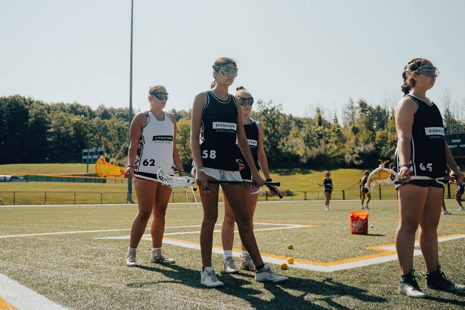 A group of female lacrosse players standing together during practice