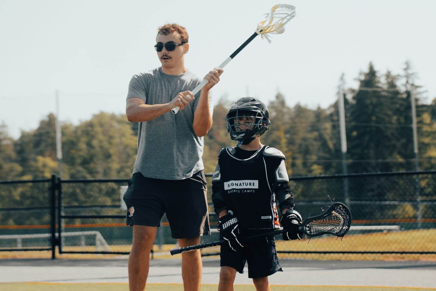 Professional lacrosse player giving one on one instruction to a young player