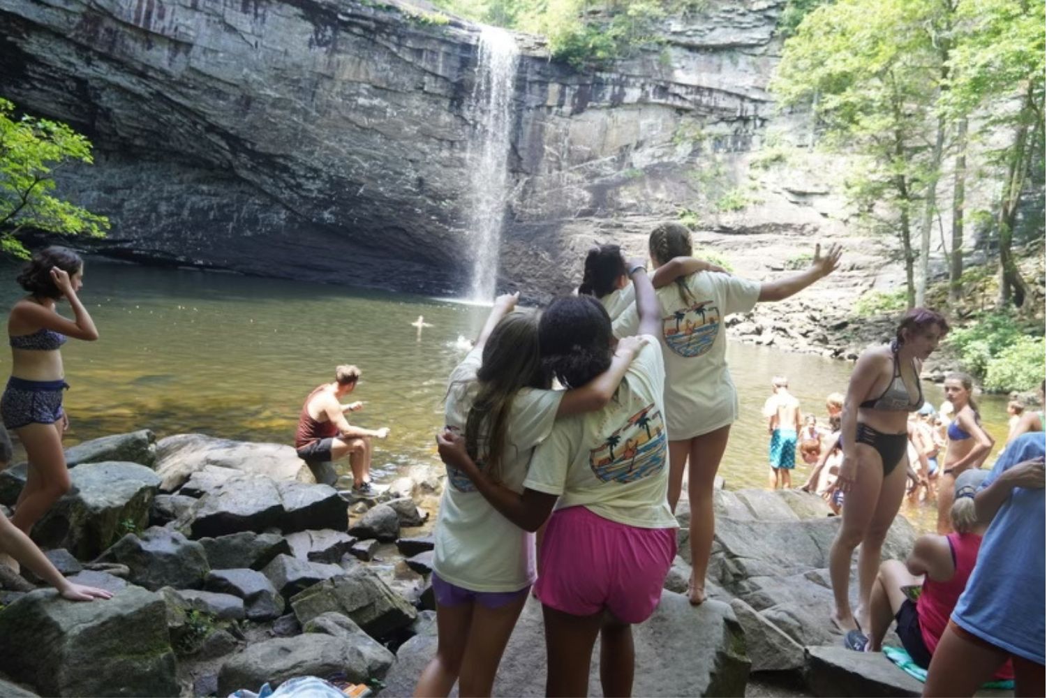 Camp friends enjoying time on the rocks at a waterfall in TN