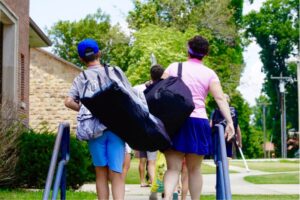 A male and female are walking up the steps to enter Lacrosse sleepaway summer camp