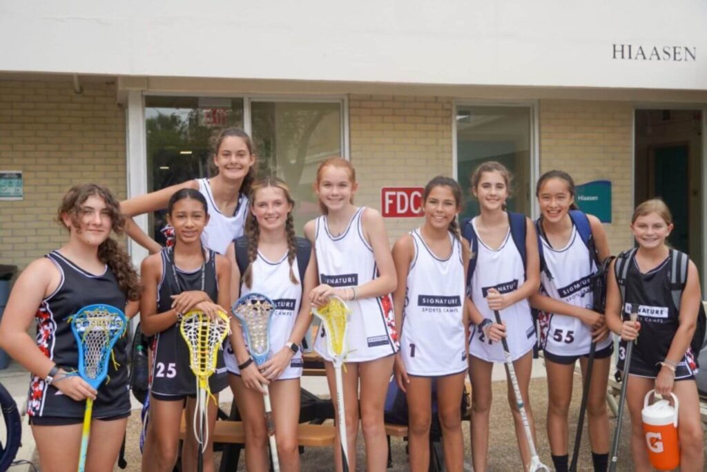A group of female lacrosse players posing together at overnight summer sports camp
