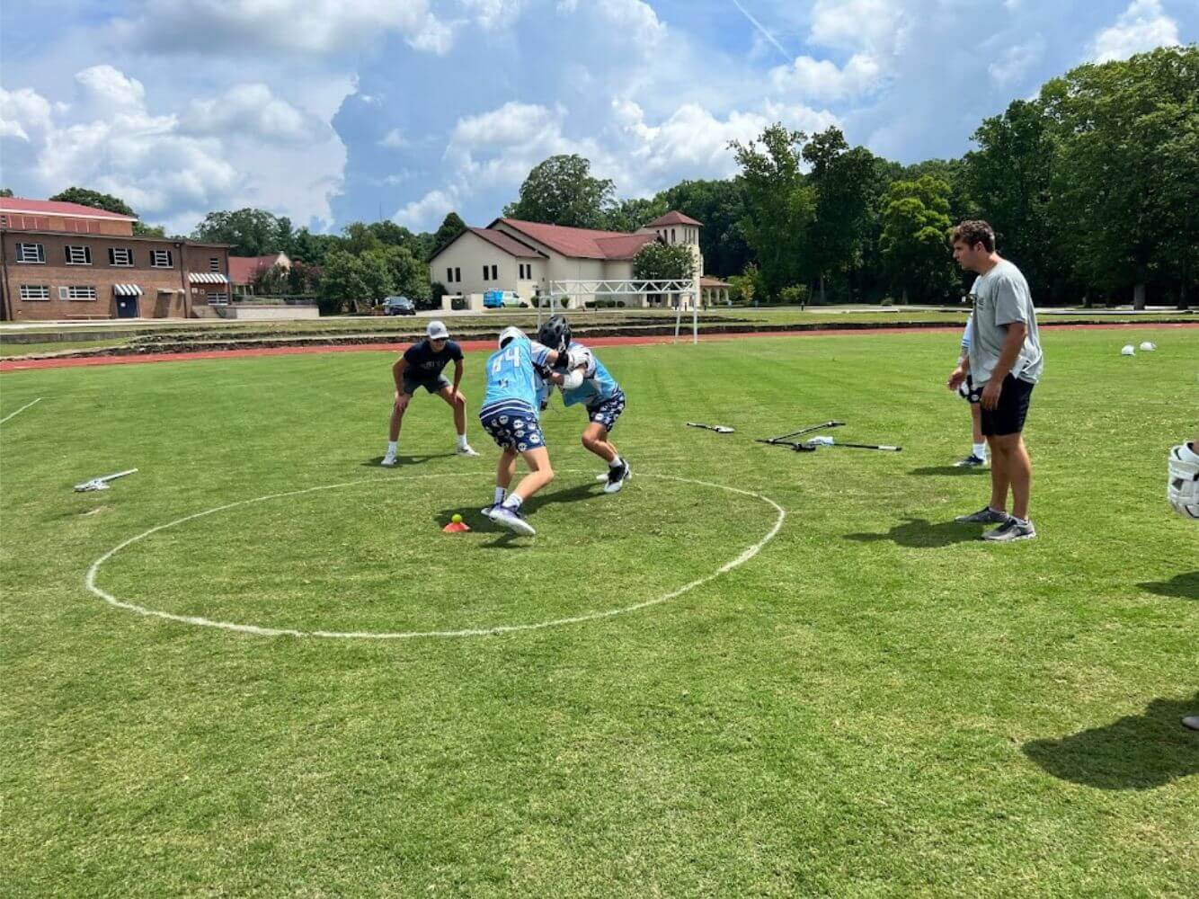 Lacrosse players practicing a defense drill during lacrosse summer camp