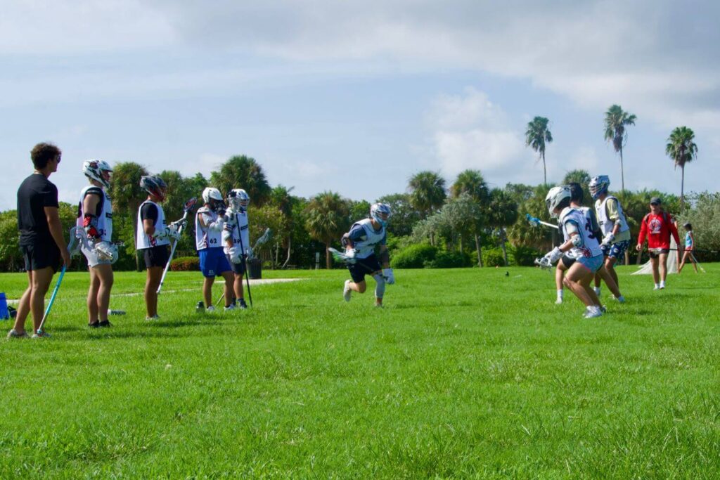 A group of youth lacrosse players are lined up during a drill at overnight camp