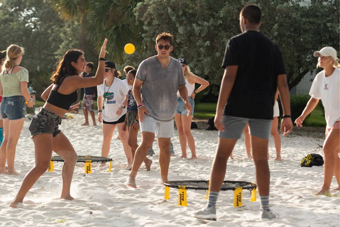 Campers and coaches playing a game of spike ball in the sand at Signature's FL overnight sports camp