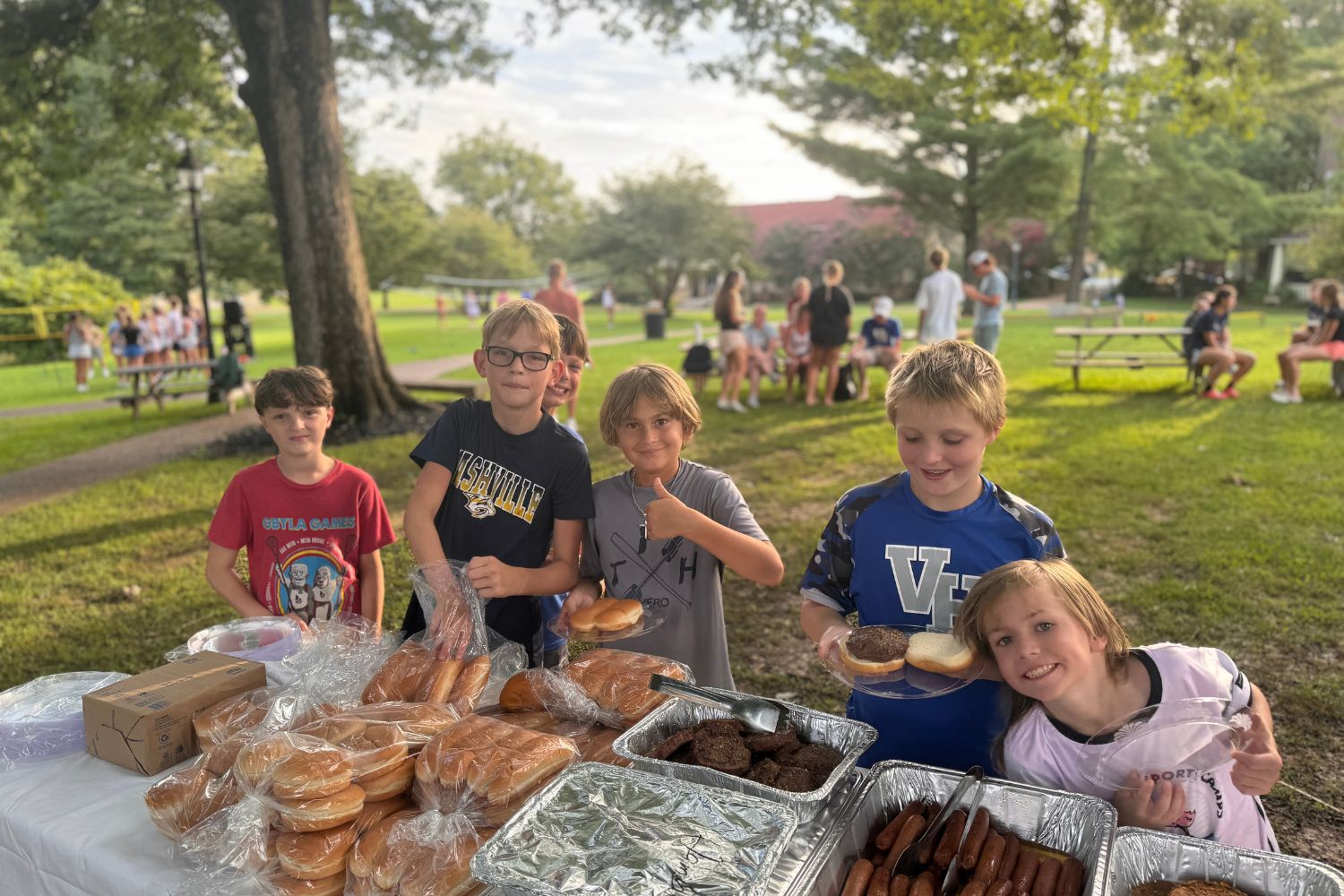 Boys pose for a photo at the BBQ table during Signature Sports Camp