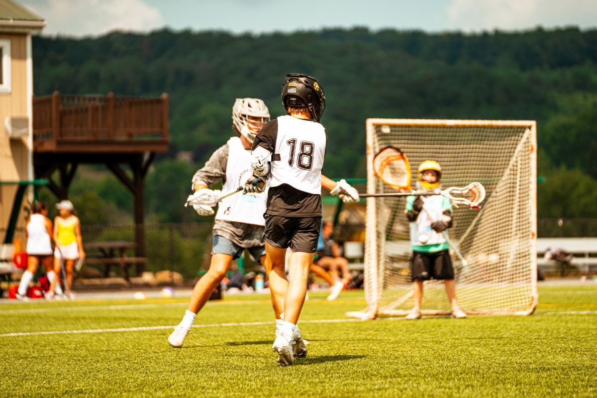 Boys playing a lacrosse scrimmage on an outdoor field