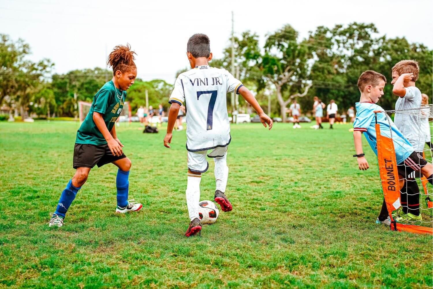 Boys dribbling soccer ball during sports camp