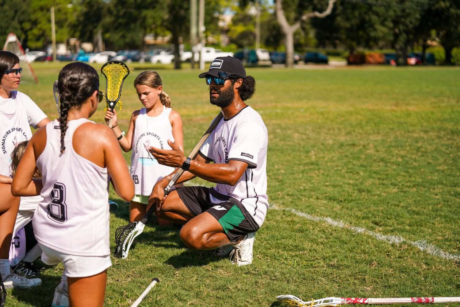 Resident coach talking to girls lacrosse group