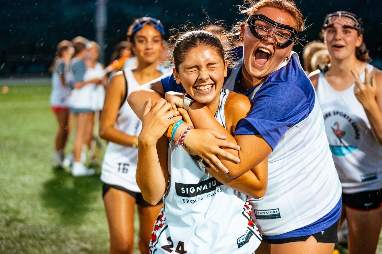 Girls holding each other and screaming with excitement at lacrosse camp