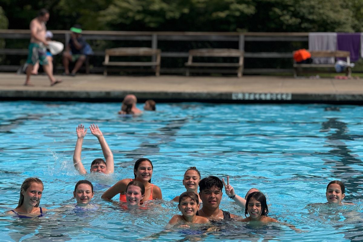 Kids at summer camp posing for a photo while in the swimming pool