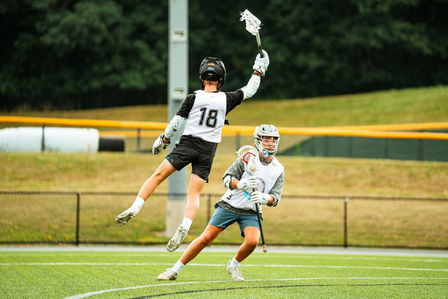 Action shot of two lacrosse players during practice at sports camp