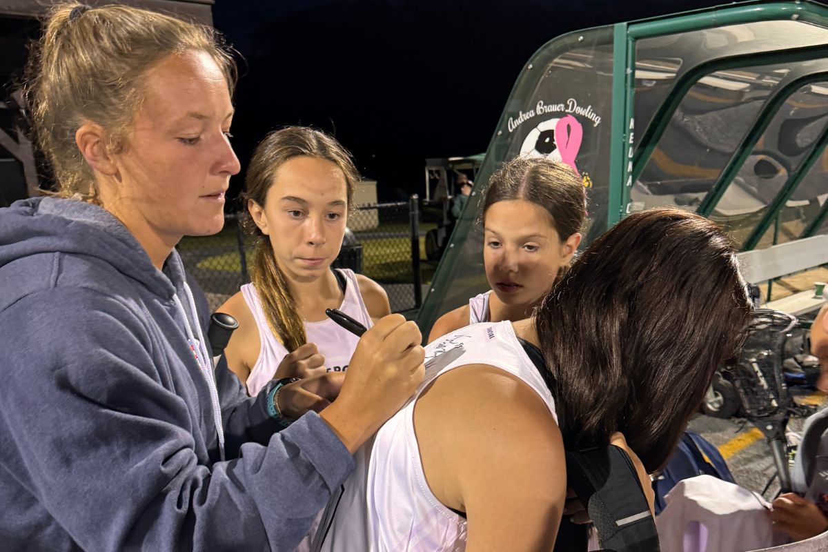 Professional lacrosse player signing autographs for campers at sports camp