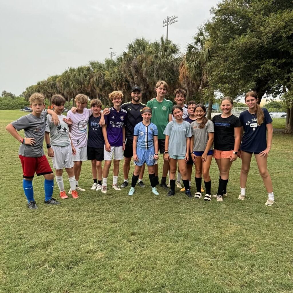 Professional footballer Nicky Law posing with a group of soccer campers for a photo