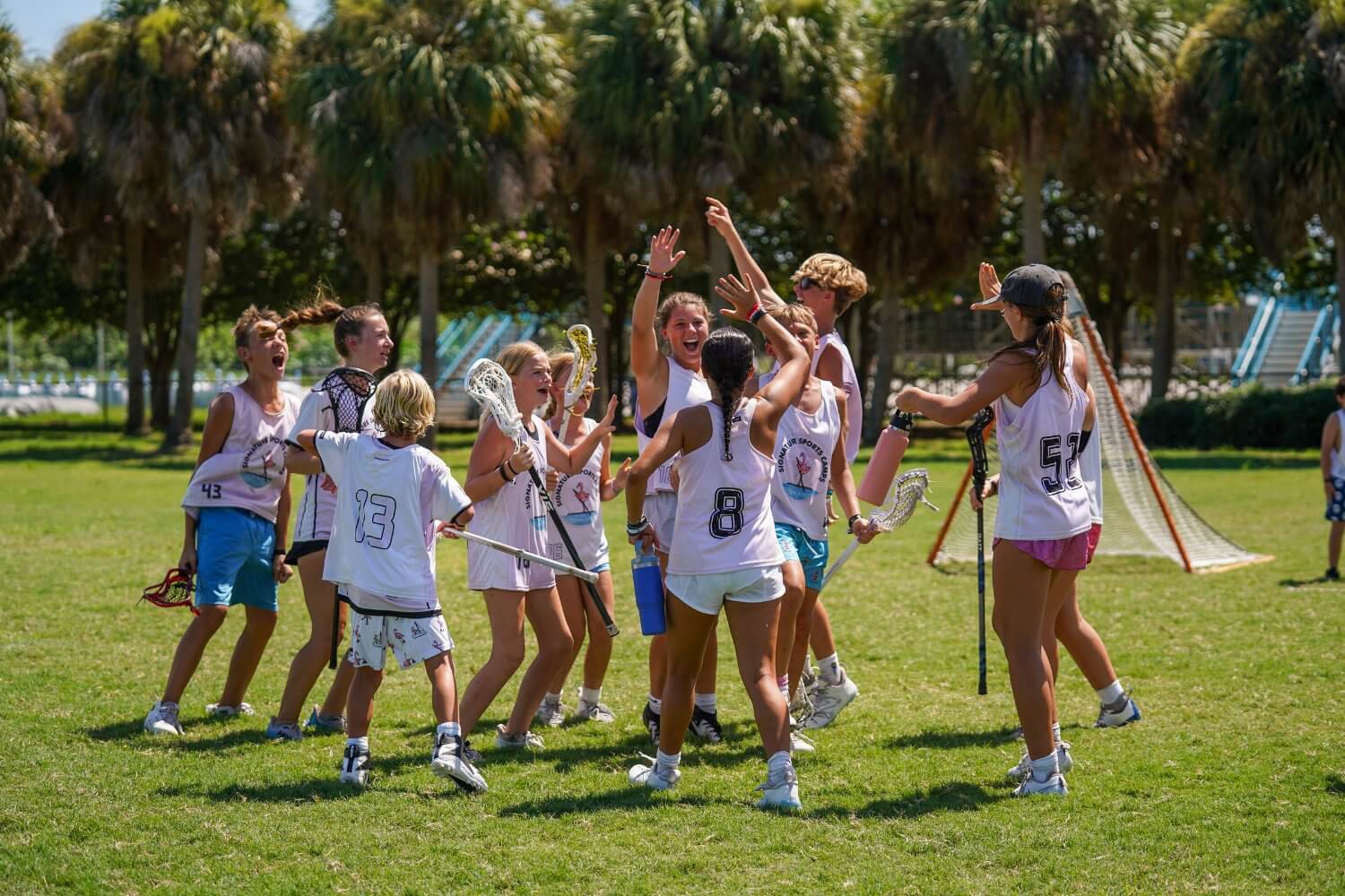 Team of lacrosse players high fiving to celebrate a win