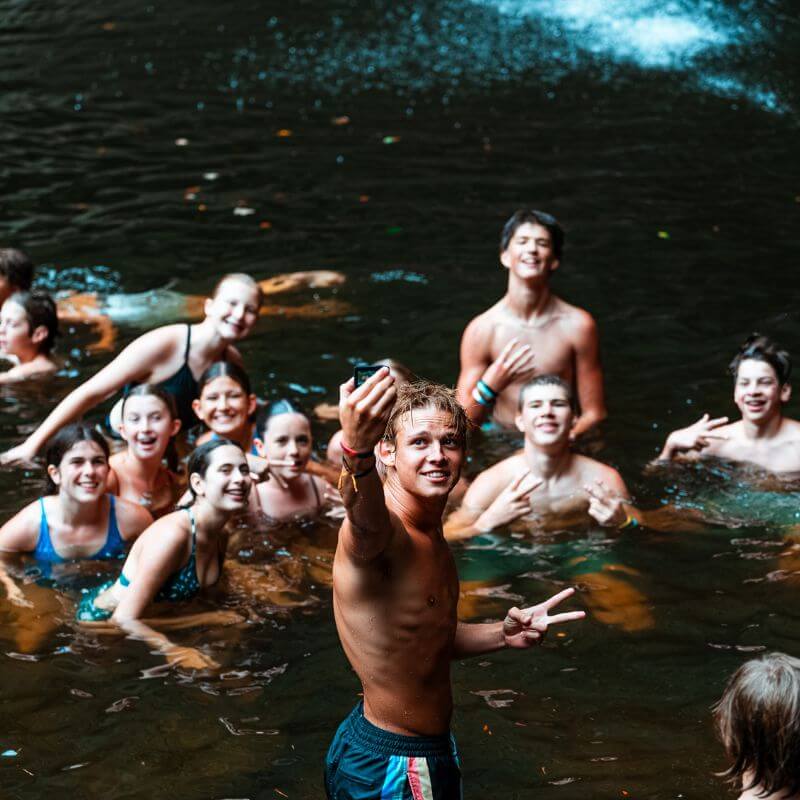 A group of campers smile for a selfie while in the swimming hole at sports camp in TN