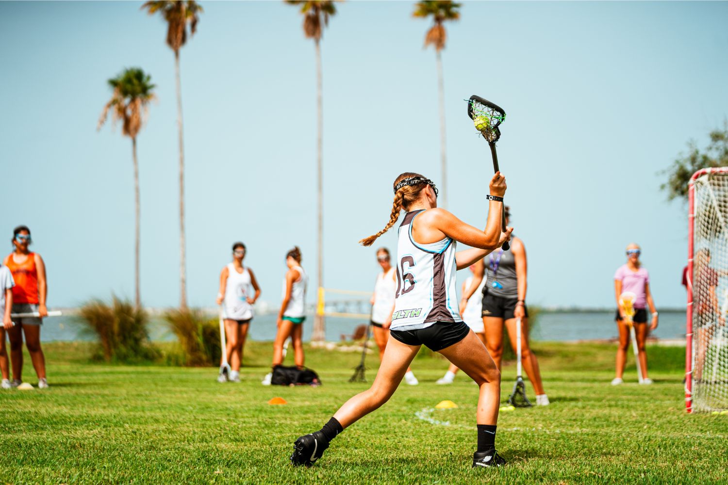 Female lacrosse player shooting a goal during practice at overnight sports camp